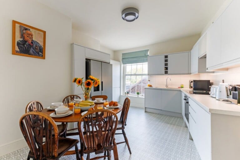 Kitchen and dining table set for breakfast at Consorts & Concubines on Thames Street, Windsor.